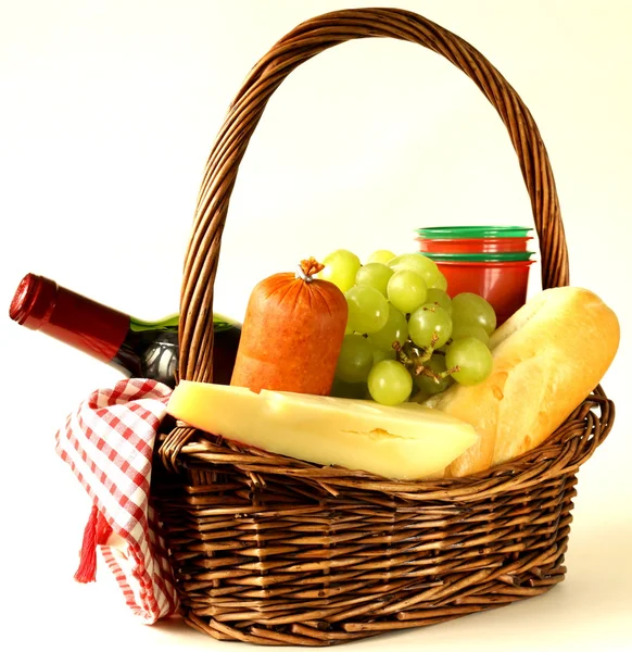 Piknik kosár - bor, gyümölcs, sajtok és kolbász, tónusú fénykép — Stock Fotó