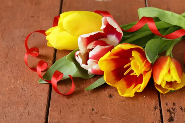 Spring tulips flowers on a wooden background — Stock Photo, Image