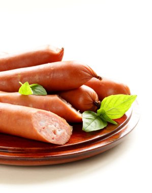 Fesleğenli ahşap plaka lezzetli tütsülenmiş sosis bırakır