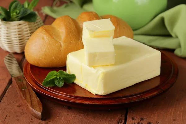 Pedazo de mantequilla fresca para el desayuno en una tabla de madera — Foto de Stock