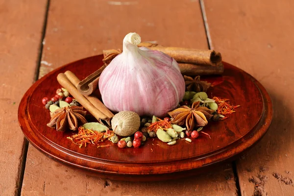 Various spices and garlic (cinnamon, star anise, saffron, pepper, cardamom) — Stock Photo, Image