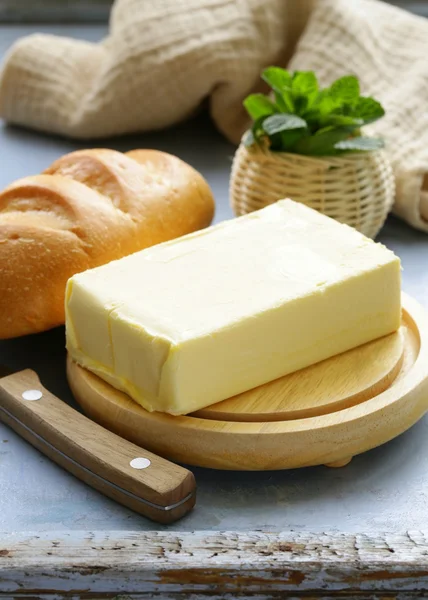 Piece of fresh butter for breakfast on a wooden board — Stock Photo, Image