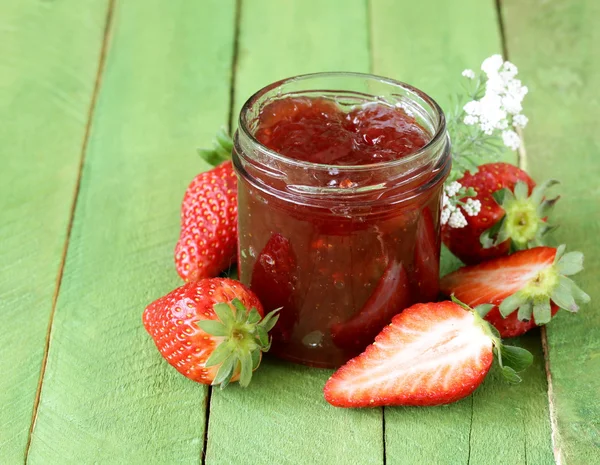 Erdbeermarmelade mit frischen Beeren im Glas auf dem Tisch — Stockfoto