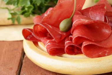 Smoked meat bresaola snack on a cutting board clipart