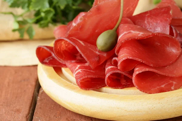 Lanche de bresaola de carne defumada em uma placa de corte — Fotografia de Stock