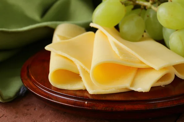 Сир, поданий на дерев'яній дошці з зеленим виноградом — стокове фото