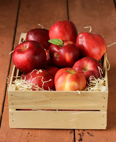 Maçãs vermelhas orgânicas maduras frescas numa caixa de madeira — Fotografia de Stock