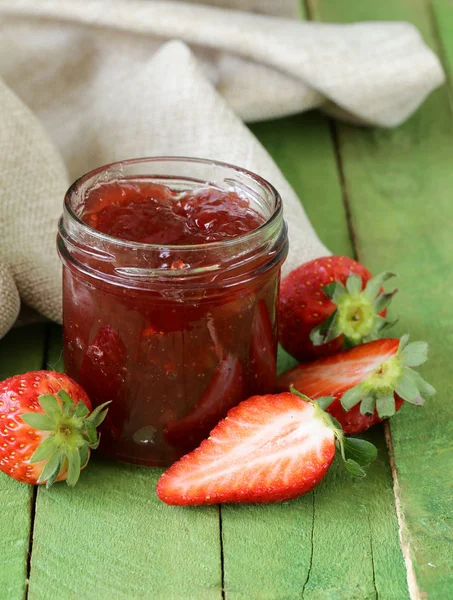 Jahodový džem s čerstvým ovocem ve sklenici na stůl — Stock fotografie