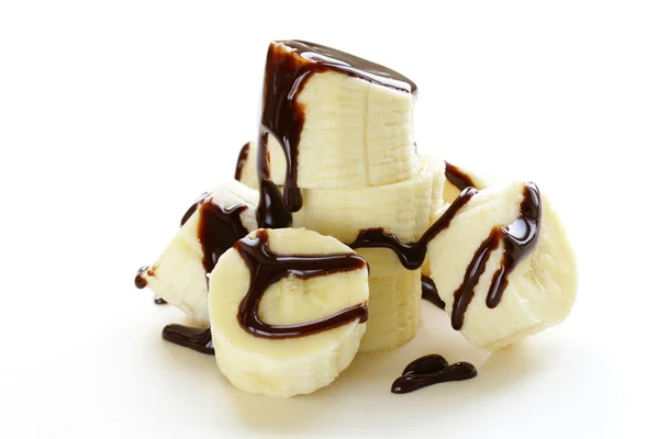 Banana matura fresca con salsa al cioccolato su sfondo bianco — Foto Stock