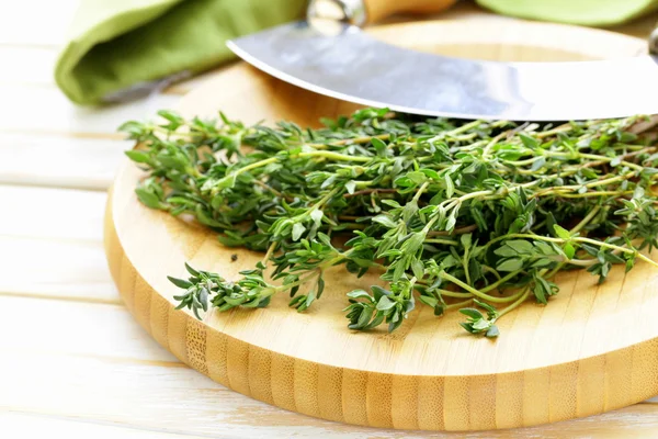 Färsk grön doftande timjan på en skärbräda — Stockfoto