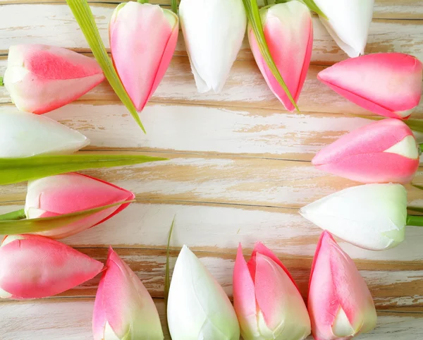 Květiny bílé a růžové tulipány na dřevěné pozadí — Stock fotografie