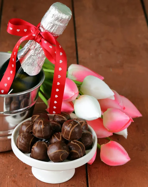 Romantische stilleven champagne, bloemen tulpen, chocolade — Stockfoto