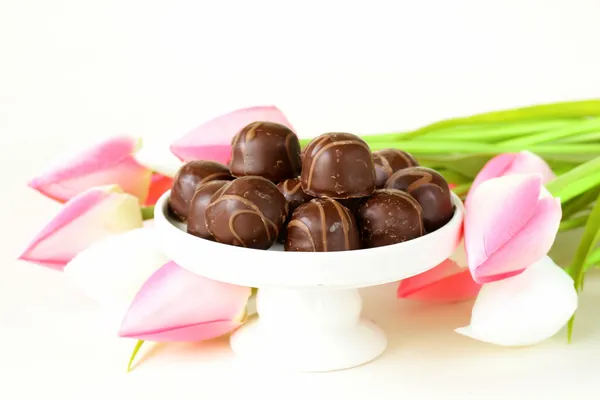 巧克力糖果和鲜花在白色背景上 — 图库照片
