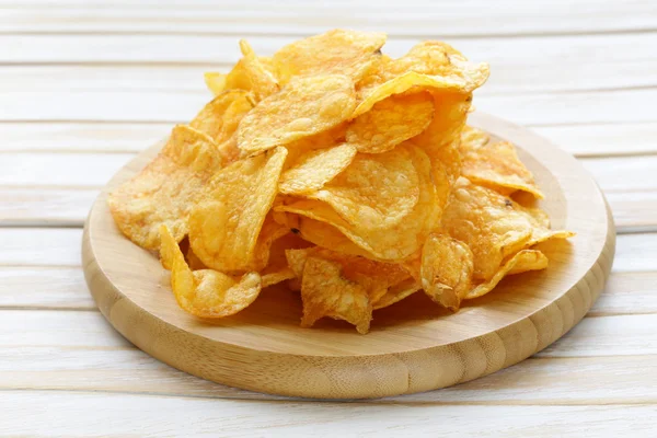 Kartoffelchips mit Paprika in einer Schüssel auf einem Holztisch — Stockfoto