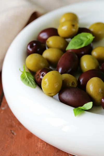 Nakládané zelené a černé olivy (kalamata) v keramické misce — Stock fotografie