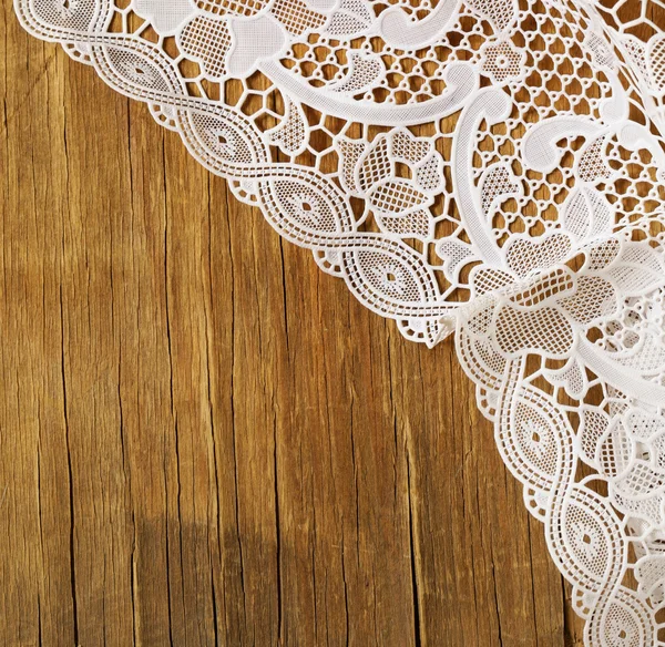 Old wooden background with white lace napkin — Stock Photo, Image