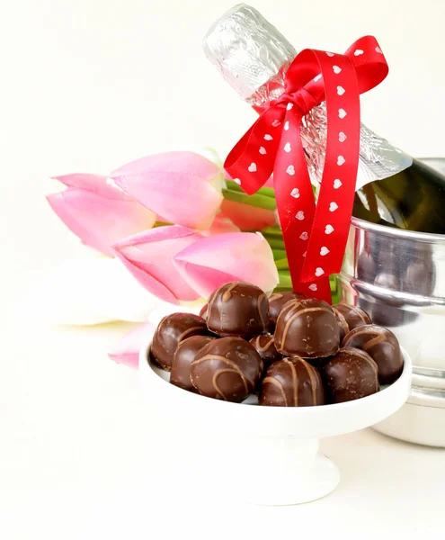 Romantiska stilleben champagne, blommor-tulpaner, choklad — Stockfoto