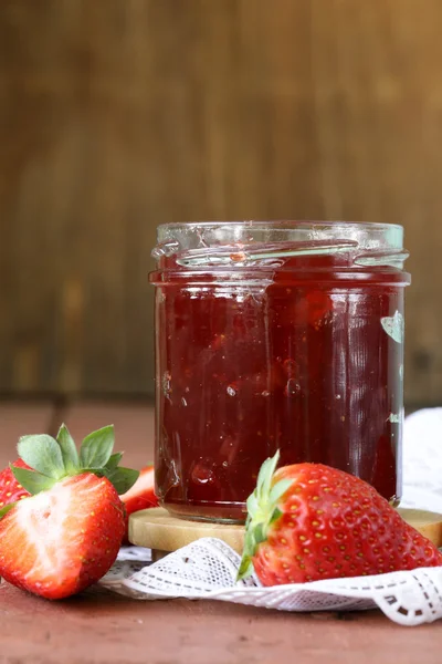 Marmellata di fragole con bacche fresche in un barattolo sul tavolo — Foto Stock