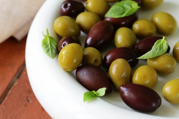 Nakládané zelené a černé olivy (kalamata) v keramické misce — Stock fotografie