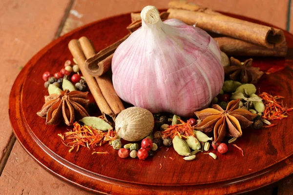Various spices and garlic (cinnamon, star anise, saffron, pepper, cardamom) — Stock Photo, Image