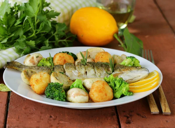 Pesce trota arrosto con verdure e limone su un piatto — Foto Stock