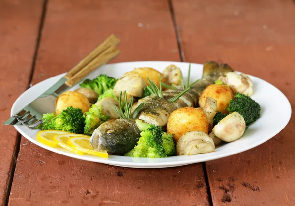 Trucha asada con verduras y limón en un plato — Foto de Stock