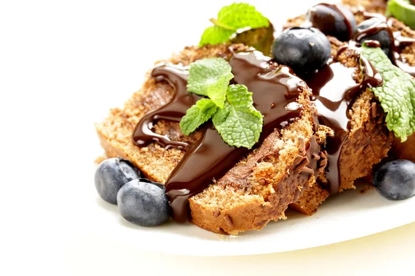 Chocolate biscuit roll garnished with mint leaves and blueberries — Stock Photo, Image