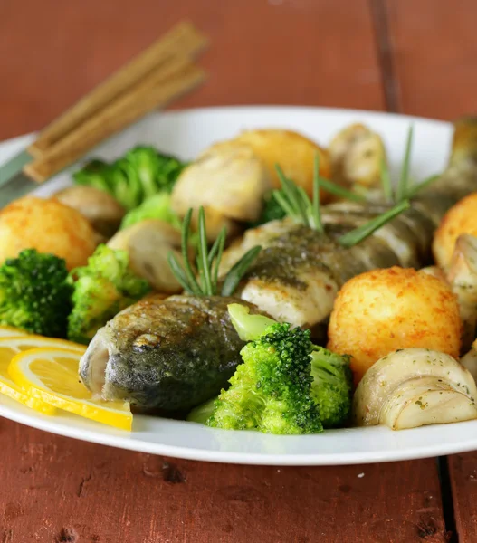 Roasted trout fish with vegetables and lemon on a plate — Stock Photo, Image