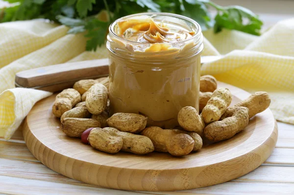 Mantequilla de maní casera con nueces enteras en una mesa de madera — Foto de Stock