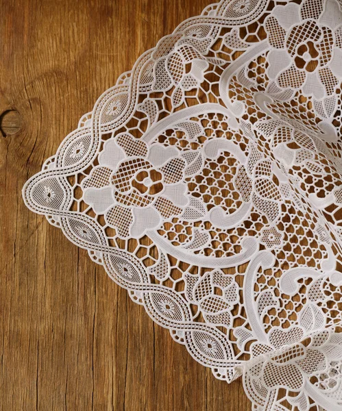 Old wooden background with white lace napkin — Stock Photo, Image
