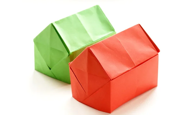 Casas de papel coloridas en origami sobre un fondo blanco —  Fotos de Stock