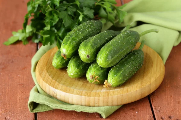 Verse rijpe groene komkommers op een houten tafel — Stockfoto