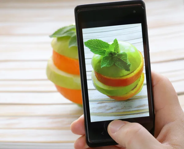 Smartphone scatto foto cibo - fette mela verde e arancia — Foto Stock