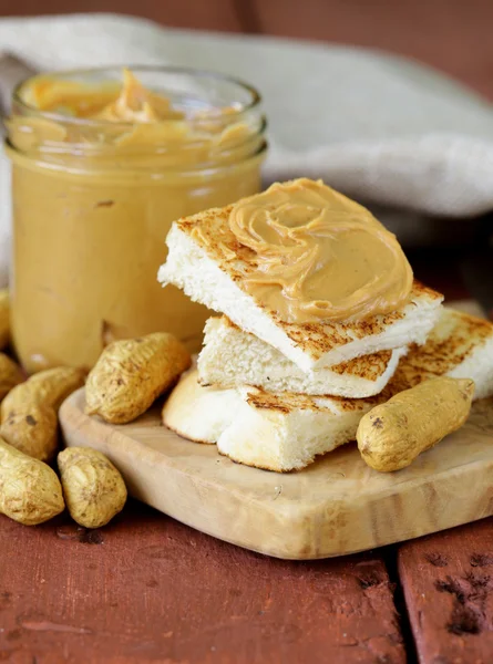 Домашнє арахісове масло з цілими горіхами на дерев'яному столі — стокове фото