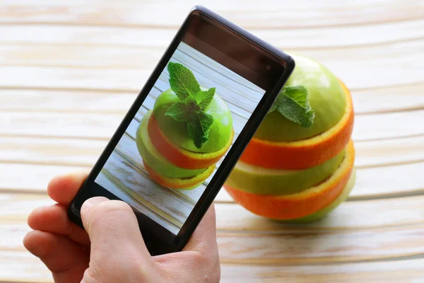 Smartphone scatto foto cibo - fette mela verde e arancia — Foto Stock