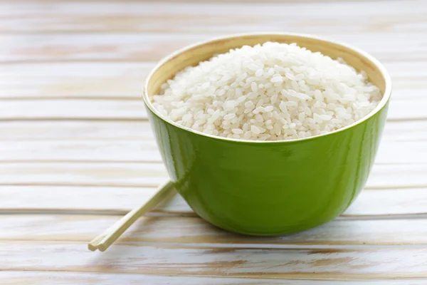 Arroz blanco sin cocer en un tazón de bambú verde —  Fotos de Stock