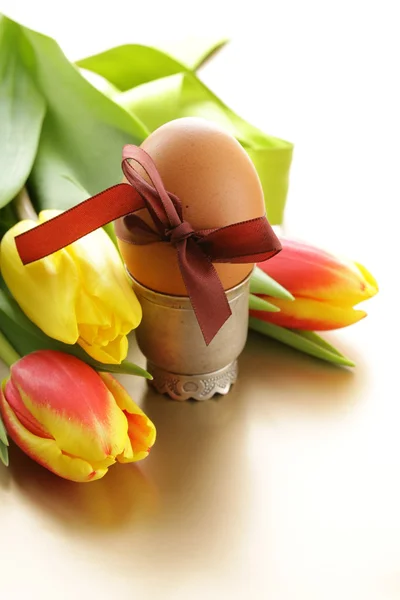 Decorated eggs and spring flowers tulips - symbols of Easter holiday — Stock Photo, Image