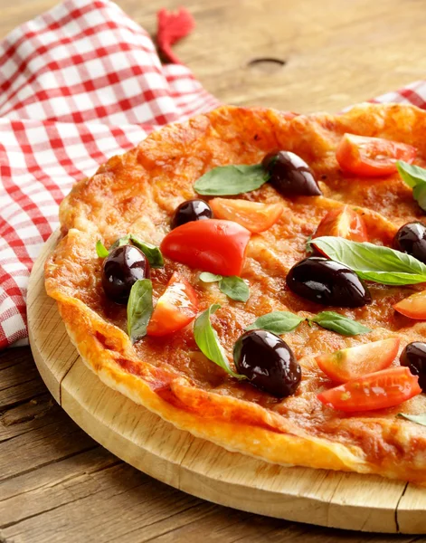 Pizza italiana com azeitonas e tomates em tábua de madeira — Fotografia de Stock