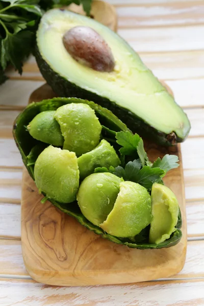 Salade van verse avocado op een houten bord — Stockfoto