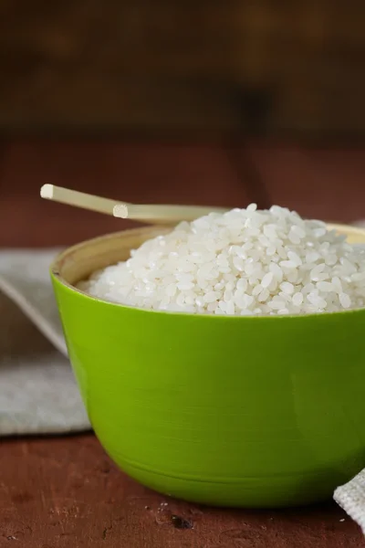 Ongekookte witte rijst in een kom groene bamboe — Stockfoto