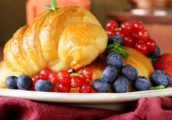 Croissant fresco com bagas para o café da manhã no prato vintage — Fotografia de Stock