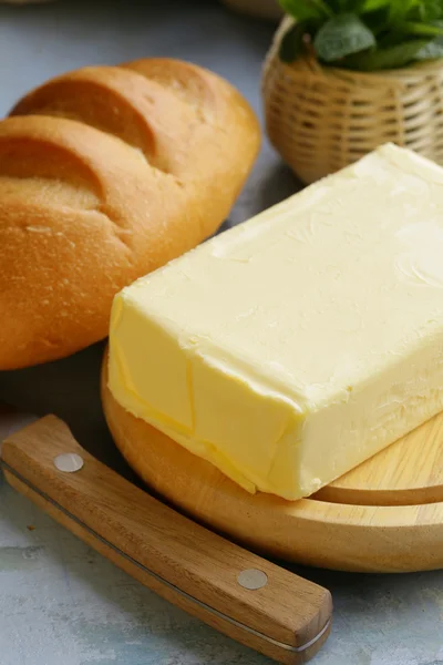 Pedazo de mantequilla fresca para el desayuno en una tabla de madera — Foto de Stock