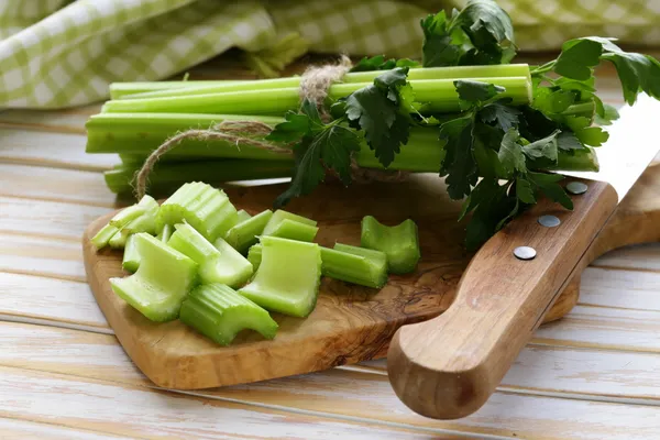 Seledri hijau cincang di papan kayu dapur — Stok Foto