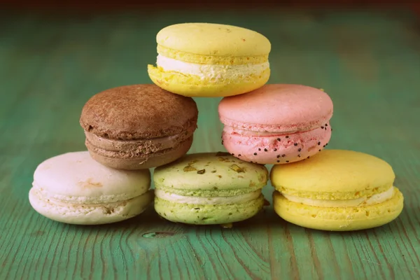 Biscoitos macaroons multicoloridos franceses em um fundo de madeira vintage — Fotografia de Stock