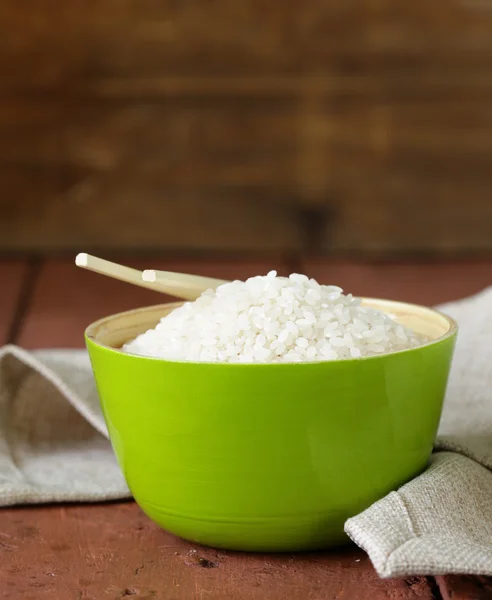 Uncooked white rice in a green bamboo bowl — 스톡 사진