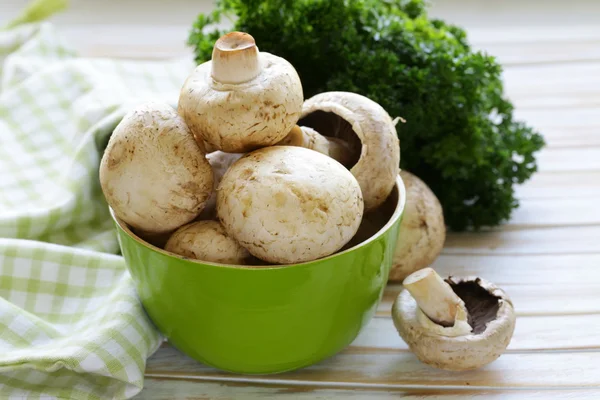 Frische Bio-Champignon-Pilze auf einem Holztisch — Stockfoto