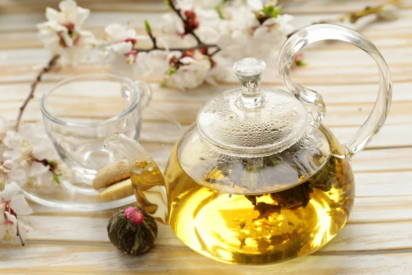 Glass teapot with exotic green tea on a wooden table — Stock Photo, Image