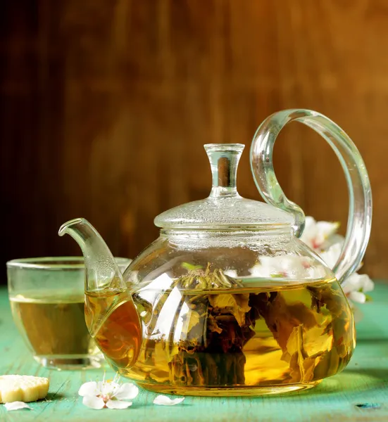Glass teapot with exotic green tea on a wooden table — Stock Photo, Image