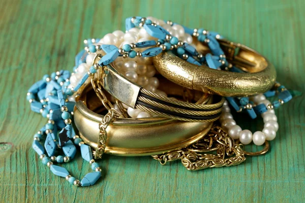 Biżuteria złota i masy perłowej na drewniane tło — Zdjęcie stockowe