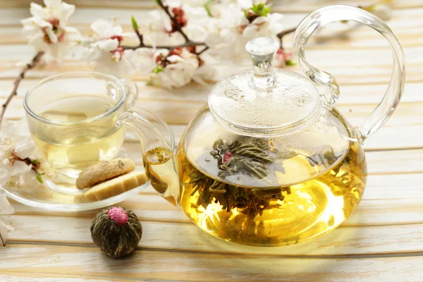 Glass teapot with exotic green tea on a wooden table — Stock Photo, Image